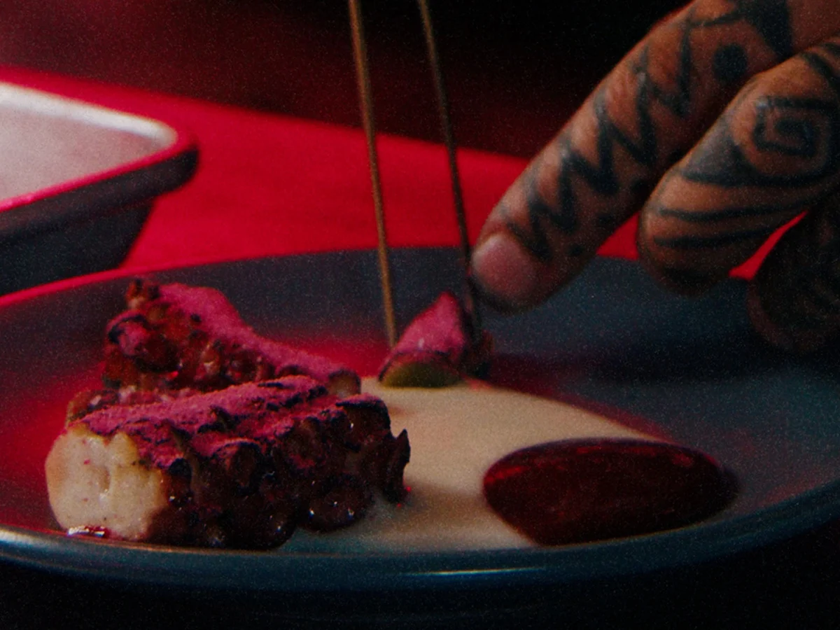 A chef finishes a plated dish with tweezers in Peninsula’s kitchen.